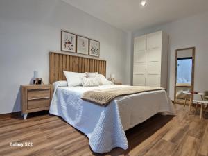 ein Schlafzimmer mit einem Bett mit hölzernem Kopfteil in der Unterkunft La Casita de Val in Valdelacalzada