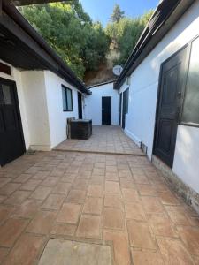 an empty courtyard between two white buildings with doors at Habitación doble en el centro con baño privado in Curicó