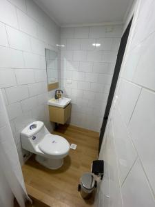 a bathroom with a white toilet and a sink at Habitación doble en el centro con baño privado in Curicó +20 photos