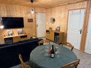 a living room with a table with wine glasses on it at Lodge des Mélèzes in Ancelle