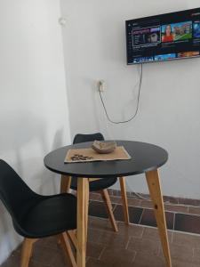 a table with a chair and a tv on a wall at MyM in Merlo