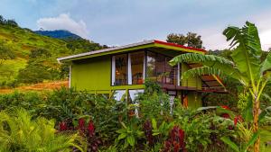 a green house in the middle of a garden at Cabañas Caeli, El Colibri, NEW La Fortuna Rainforest Cabin w Panoramic Views in San Francisco