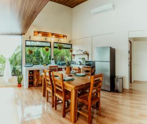 a kitchen with a wooden table and chairs at Cabañas Caeli, El Colibri, NEW La Fortuna Rainforest Cabin w Panoramic Views in San Francisco
