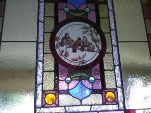 a stained glass window with a painting of animals on it at bluebird cottage in Angaston