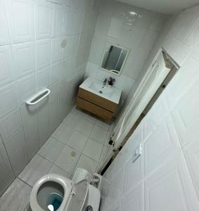 a small bathroom with a toilet and a sink at Hotel H&H in Cartagena de Indias