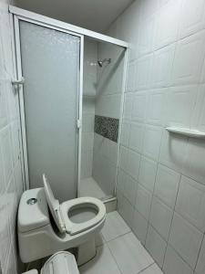 a white bathroom with a toilet and a shower at Hotel H&H in Cartagena de Indias +9 photos