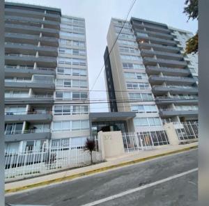 two tall apartment buildings next to a street at Monkey Guest Apartment in Concón