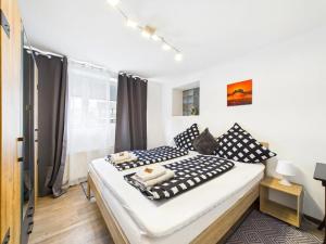 Apartment in Kordel في Kordel: غرفة نوم بسرير كبير ومخدات بيضاء وسوداء