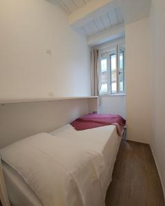 una camera da letto bianca con un letto e una finestra di NALI Apartment 1 a Civitanova Marche