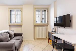 San Sisto Apartment في بياتشينزا: غرفة معيشة مع أريكة وتلفزيون بشاشة مسطحة