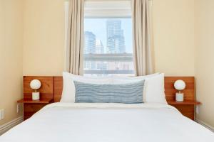 a bedroom with a large white bed with a window at Kasa Gaslamp Quarter San Diego in San Diego