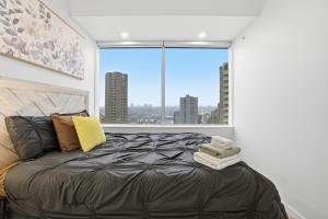 Un dormitorio con una cama con una ventana grande. en Luxury 1Beds and 2Beds in Downtown Edmonton close to Rogers, en Edmonton