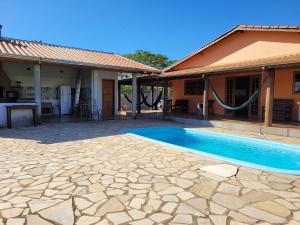 a house with a swimming pool next to a house at Chácara Recanto Colibri in Socorro