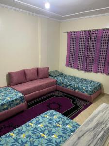 a living room with a couch and two ottomans at Chez ZAKi in Meknès +1 photo