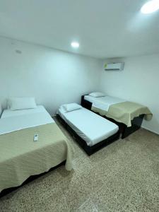 a room with two beds in a room at Hotel H&H in Cartagena de Indias