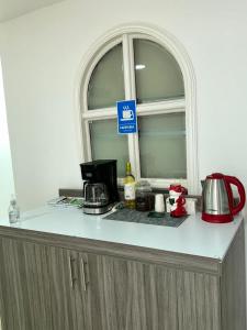 a kitchen counter with a window and a coffee maker at Hotel H&H in Cartagena de Indias