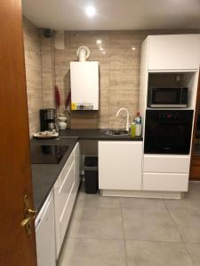 a kitchen with white cabinets and a sink at Gîte au cœur du vignoble in Riquewihr