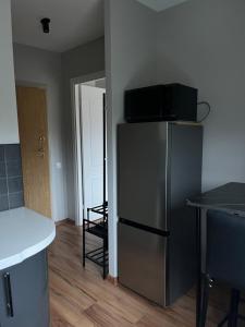 a kitchen with a stainless steel refrigerator and a table at Cozy Stay Dubulti in Jūrmala