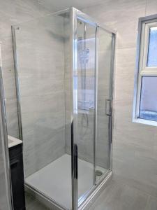 a shower with a glass door in a bathroom at Modern One Bedroom Flat With Garden in Cardiff