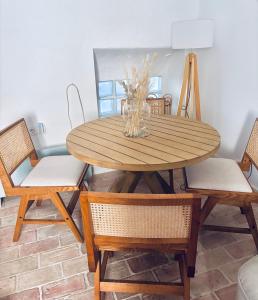 a wooden table with two chairs and a vase on it at Halona Casa Rural in Bullas