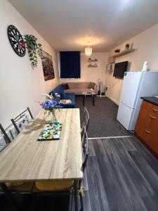 a kitchen and living room with a table and a couch at Airrose two bed apartment in Wolverhampton
