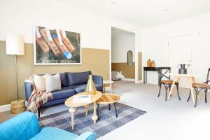 a living room with a blue couch and a table at Kasa Del Ray Alexandria in Alexandria +3 photos