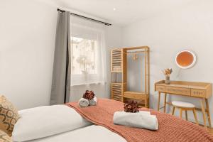 a bedroom with a bed and a desk and a window at Deluxe Apartment Dingolfing - Design & Space in Dingolfing