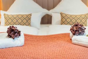 a bed with two towels and flowers on it at Deluxe Apartment Dingolfing - Design & Space in Dingolfing +18 photos