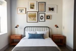 a bedroom with a bed with four pictures on the wall at Kasa Altmayer Savannah in Savannah