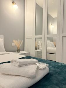 a white room with two beds and towels on a bed at AB apartment Pistoia in Pistoia