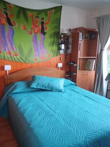 a bedroom with a bed with a blue comforter at Hermoso loft a pasos del plan de Valparaíso in Valparaíso