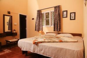 ein Schlafzimmer mit einem großen Bett mit Fenster in der Unterkunft Nadhi Teera Riverside Stay in Kushālnagar