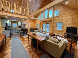 a large living room with a couch and a table at 2S New log cabin in Bethlehem - privacy, firepit, great location! in Bethlehem