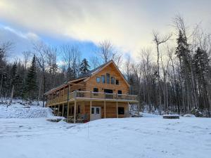 a large wooden house in the snow in the woods at 2S New log cabin in Bethlehem - privacy, firepit, great location! in Bethlehem