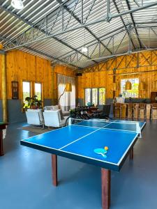 mesa de ping pong en una habitación con paredes de madera en Morada Das Grimpas, en Palmeira