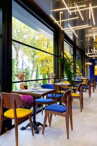 a restaurant with tables and chairs and a large window at Art Hotel in Chişinău