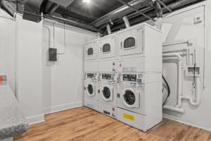 a laundry room with three washing machines in it at Kasa La Monarca San Francisco in San Francisco