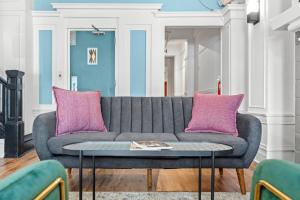 a living room with a gray couch and pink pillows at Kasa La Monarca San Francisco in San Francisco
