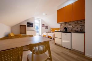 a kitchen and living room with a table and chairs at Pharmácia- Alojamento local in Miranda do Corvo