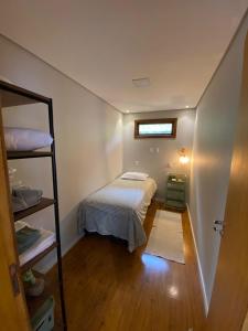 ein kleines Schlafzimmer mit einem Bett und einem Fenster in der Unterkunft Casa da Rota dos Ipês in Domingos Martins