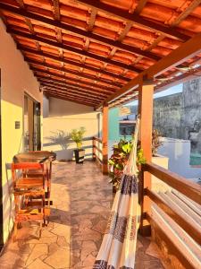 um pátio com mesa e cadeiras em uma varanda em Refúgio Colonial - Figueira - Praia de Mauá em Majé