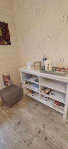 un estante blanco con libros en una habitación en L'Ecureuil Gourmand, chambre d'hôtes en Anjou Bleu, en Saint-Martin-du-Bois