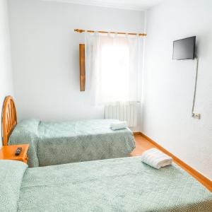 un soggiorno con due letti e una TV di Pensión San Cristóbal by Bossh! Hotels a Cuenca