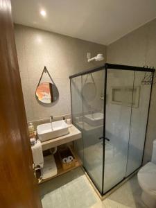 ein Badezimmer mit Glasdusche und Waschbecken in der Unterkunft Casa da Rota dos Ipês in Domingos Martins + 19 Fotos