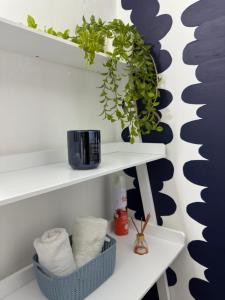 a bathroom with white shelves with plants on them at Bamuka Hostal in Bogotá