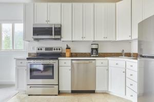 a kitchen with white cabinets and stainless steel appliances at Kasa Del Ray Alexandria in Alexandria