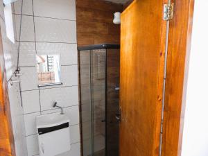a bathroom with a shower and a glass door at Pousada 4 Estações in Botucatu