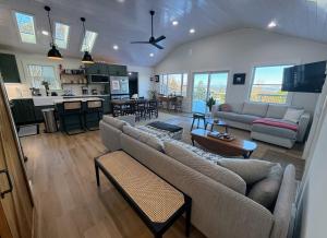 a living room with two couches and a kitchen at 2T Bethlehem Retreat with Stunning Sunset Views in the Heart of the White Mountains in Bethlehem