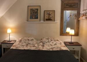 Stor lägenhet i Elofstorps Missionshus في كريستينهامن: غرفة نوم بها سرير ومصباحان على طاولتين