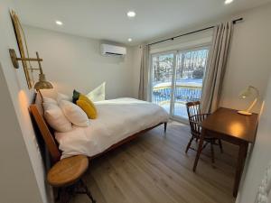 a bedroom with a bed and a desk and a window at 2T Bethlehem Retreat with Stunning Sunset Views in the Heart of the White Mountains in Bethlehem +49 photos